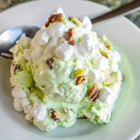 Bright green Watergate Salad with marshmallow pieces, perfect for a summer gathering.