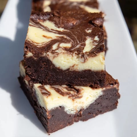 Beautifully swirled cheesecake brownies, a decadent dessert, perfect for any occasion's treat.