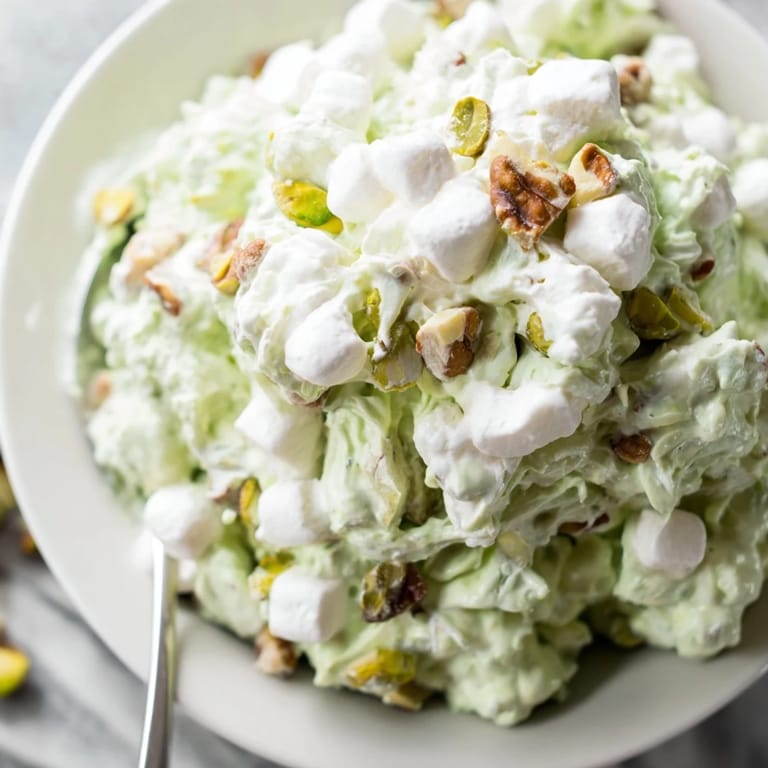 Close-up of creamy Watergate Salad, showing pineapple chunks and a pistachio hue.