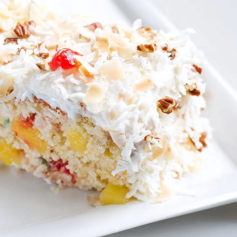 Warm, golden Fruit Cocktail Cake freshly baked, adorned with a creamy, coconutty frosting.