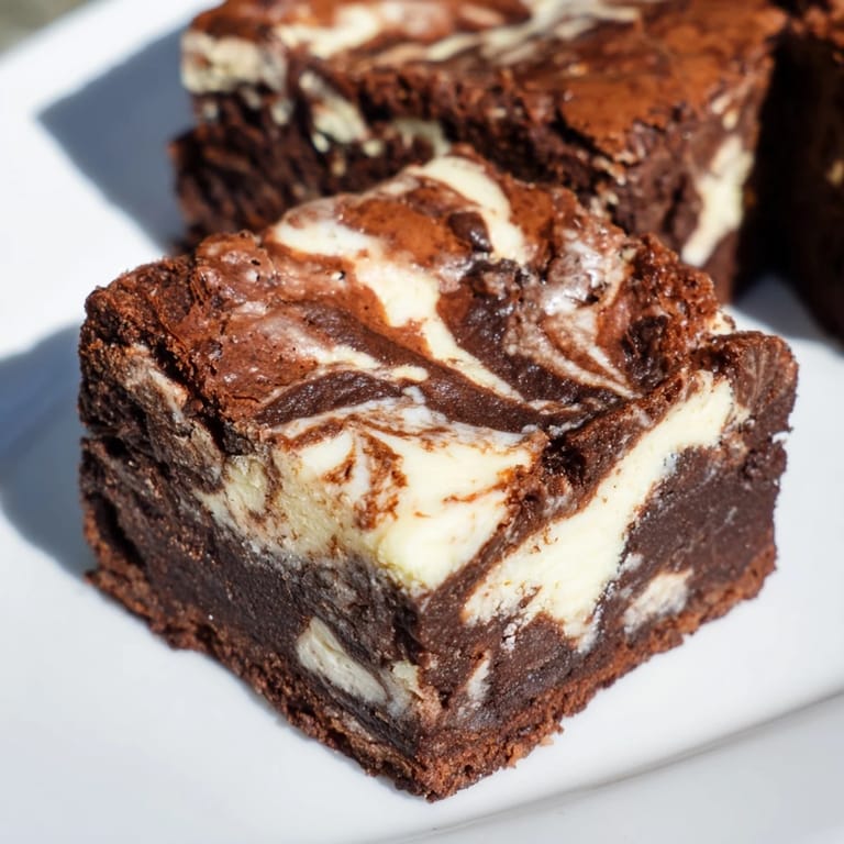 Indulge in a close-up of these luscious cheesecake brownies with a rich, chocolatey aroma.