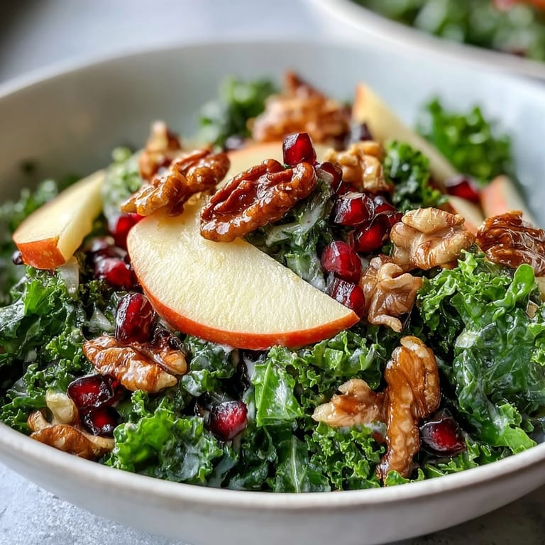 Kale and Pomegranate Bowl served as a vibrant vegetarian salad topped with walnuts, sliced apples, and a sweet-savory mustard dressing.