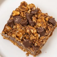 Golden, gooey Hello Dolly Bars, freshly baked and ready to be sliced, perfect for a party.