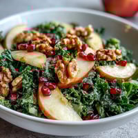 Fresh massaged kale tossed with pomegranate seeds, crisp apple slices, and crunchy walnuts, all drizzled with tangy apple cider vinaigrette.
