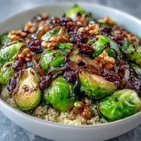 Roasted Brussels Sprouts Bowl with caramelized vegetables and hearty grains, drizzled with tangy balsamic dressing for a nourishing meal.